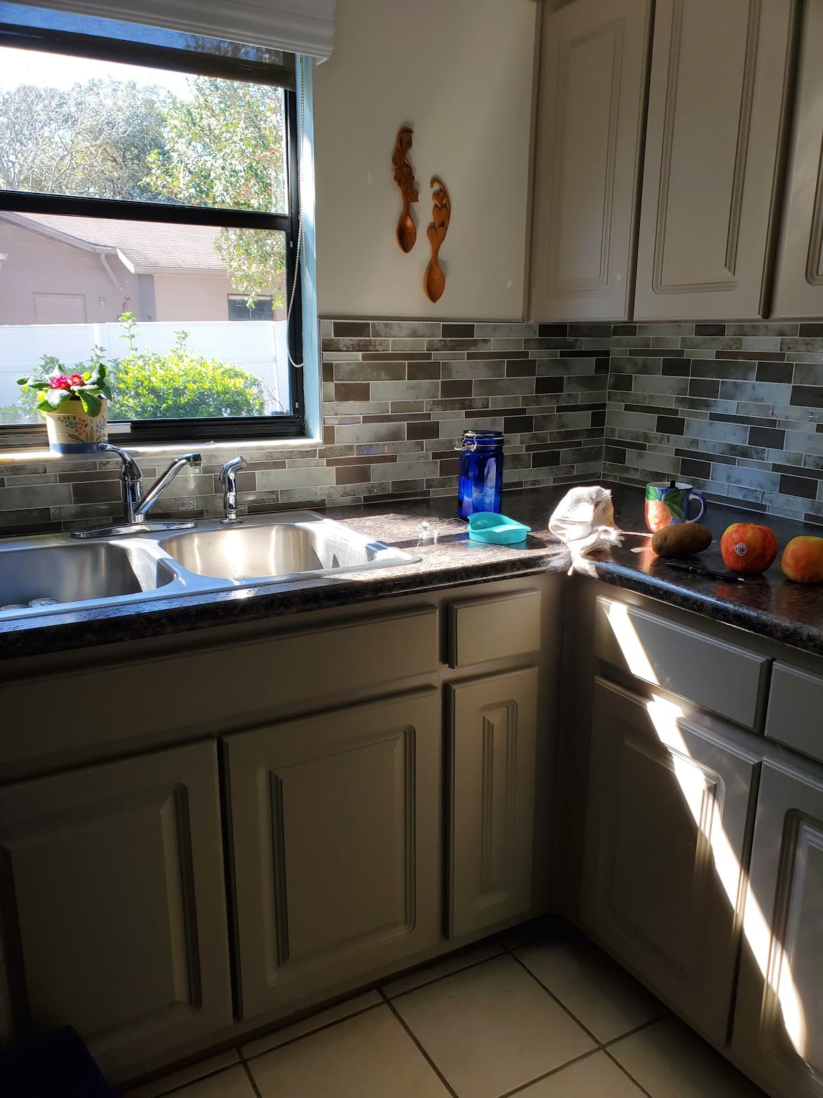 Gray shaker kitchen cabinets with stone backsplash and dark countertops remodeled by Devon's HomePro in the Tampa Bay area