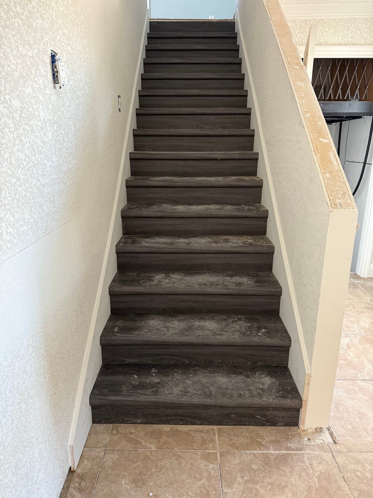 Interior staircase remodel with dark wood treads and white risers by Devon's HomePro